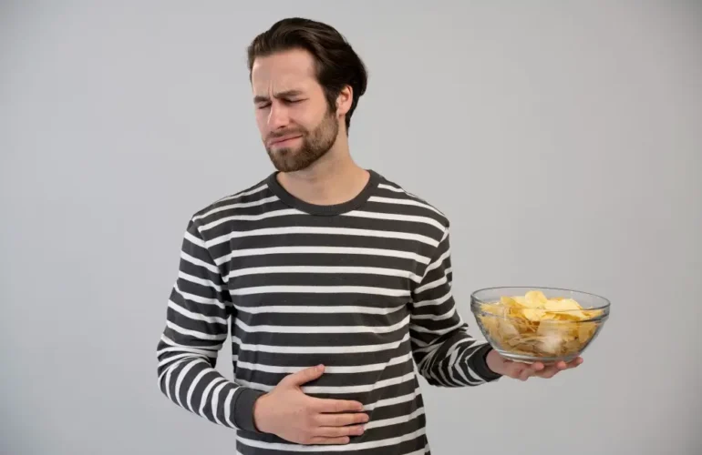 Woman experiencing abdominal pain after eating oily food due to gallstones