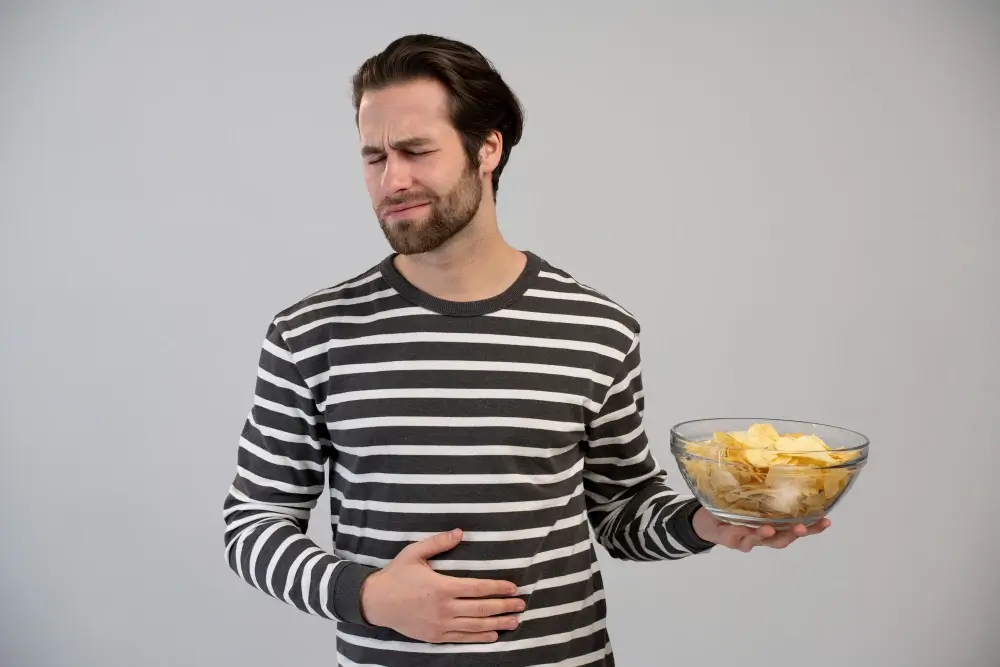 Woman experiencing abdominal pain after eating oily food due to gallstones